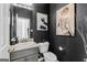 Chic half-bathroom featuring dark walls, modern art, a pedestal sink, and a toilet at 65 Hill Top Cir, Grantville, GA 30220