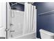 Clean white bathtub and shower combination with chrome fixtures and white shower curtain at 65 Hill Top Cir, Grantville, GA 30220