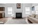 Living room with a cozy fireplace, modern decor, and two large windows at 65 Hill Top Cir, Grantville, GA 30220
