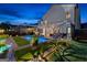 Gorgeous backyard at night featuring a private pool and lounge area with stylish lighting at 65 Hill Top Cir, Grantville, GA 30220