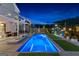 Stunning backyard with a pool, lounge area, and shade, illuminated by string lights at twilight at 65 Hill Top Cir, Grantville, GA 30220