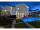 The backyard at night featuring a pool, outdoor kitchen, and lounge area with modern design at 65 Hill Top Cir, Grantville, GA 30220