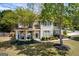 Inviting two-story house featuring stone details, a cozy front porch with seating, and lush greenery at 1212 Dayspring Trce, Lawrenceville, GA 30045