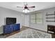 Spacious bedroom with a ceiling fan, hardwood floors, a blue dresser, and a gray rug at 100 Ashland Trl, Tyrone, GA 30290