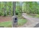 Long driveway with a stone mailbox surrounded by lush green trees and landscaping at 100 Ashland Trl, Tyrone, GA 30290