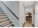 Hallway view with staircase and a peek into a bedroom featuring hardwood flooring at 100 Ashland Trl, Tyrone, GA 30290