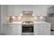 Kitchen area showcasing stainless steel oven and cooktop with updated cabinetry and backsplash at 100 Ashland Trl, Tyrone, GA 30290