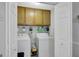 Laundry room with overhead cabinets, shelving, washer, dryer, and closet space at 100 Ashland Trl, Tyrone, GA 30290