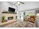 Cozy living room features a stone fireplace, neutral walls, and an open layout to the kitchen at 100 Ashland Trl, Tyrone, GA 30290