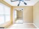 A sunlit bedroom with a ceiling fan, mirrored closet doors, neutral walls, and light wood flooring at 110 Tamarack Trl, Mcdonough, GA 30252