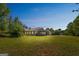 Ranch-style home featuring a covered front porch, attached garage, spacious lawn, and basketball court on a clear, sunny day at 110 Tamarack Trl, Mcdonough, GA 30252