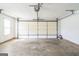 Spacious two-car garage with concrete floor and walls, an automatic door, and a single window at 110 Tamarack Trl, Mcdonough, GA 30252