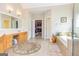Bright bathroom featuring dual vanities, a soaking tub, and access to a walk-in closet at 325 Elderberry Trl, Fayetteville, GA 30214