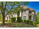 Stunning two-story brick home with lush landscaping and mature trees at 325 Elderberry Trl, Fayetteville, GA 30214