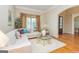 Comfortable living room with a white sectional sofa, a glass coffee table, and hardwood floors at 325 Elderberry Trl, Fayetteville, GA 30214