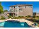 Backyard view of pool, deck, and multi-story brick home with manicured landscaping at 325 Elderberry Trl, Fayetteville, GA 30214
