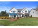 Beautiful two-story home with a lush green lawn, shrubs, and manicured landscaping at 284 Villa Grande Dr, Locust Grove, GA 30248