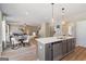Modern kitchen with gray island, stainless appliances, and an adjacent living area at 284 Villa Grande Dr, Locust Grove, GA 30248