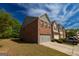 Inviting townhome showcasing brickwork, attached garage, and manicured landscaping at 3526 Brockenhurst Dr, Buford, GA 30519