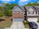Beautiful townhome featuring a brick facade, attached garage, and manicured landscaping at 3526 Brockenhurst Dr, Buford, GA 30519