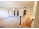 Open-concept living area featuring neutral paint, carpeted floors, and stairs with wood banister at 3526 Brockenhurst Dr, Buford, GA 30519