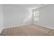 Bright bedroom featuring neutral carpet, white trim, and natural light from the window at 1144 Bluecoat Cir, Hampton, GA 30228