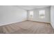 This bedroom has carpeted floors, two windows with blinds, and white walls at 1144 Bluecoat Cir, Hampton, GA 30228