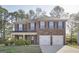 Charming two-story brick home featuring a two-car garage, inviting front porch, and manicured lawn at 1144 Bluecoat Cir, Hampton, GA 30228