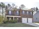 Charming two-story brick home with a well-manicured lawn and a two-car garage at 1144 Bluecoat Cir, Hampton, GA 30228