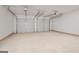 Spacious two car garage features a concrete floor and white walls at 1144 Bluecoat Cir, Hampton, GA 30228
