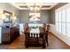 Formal dining room featuring a coffered ceiling, hardwood floors, and plantation shutters at 109 Lighthorse Blvd, Mcdonough, GA 30252