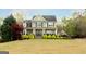 View of a traditional two-story home featuring a wide front lawn and a welcoming covered front porch at 109 Lighthorse Blvd, Mcdonough, GA 30252