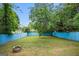 Large, fenced backyard features a stone firepit and mature trees at 3378 La Vista, Hapeville, GA 30354