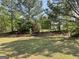 A wooded area in the distance and a grassy field are featured in the backyard at 1028 Field View Dr, Mcdonough, GA 30253