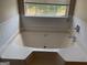 Large, beige bathtub beneath a window in a bathroom at 1028 Field View Dr, Mcdonough, GA 30253