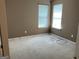 A bedroom with beige walls and carpet, featuring two windows with horizontal blinds at 1028 Field View Dr, Mcdonough, GA 30253