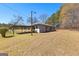 Rear view of home showcasing the covered carport and the lush lawn at 315 S Bethany Rd, Mcdonough, GA 30252