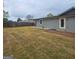 Expansive backyard showcases a sprawling dormant lawn, privacy fence, and a quaint brick patio at 487 Eastside Dr, Dacula, GA 30019