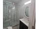 Modern bathroom features a glass shower with elegant marbled tile and a dark vanity with bright countertop at 487 Eastside Dr, Dacula, GA 30019
