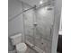 The bathroom has a glass enclosed tile shower, a toilet, a dark vanity, and wood-look flooring at 487 Eastside Dr, Dacula, GA 30019