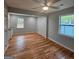 A bedroom with hardwood floors, a ceiling fan, built-in cabinets and drawers, and two windows at 487 Eastside Dr, Dacula, GA 30019