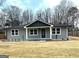 Charming single story home featuring gray siding, a green front door, and well manicured landscaping at 487 Eastside Dr, Dacula, GA 30019