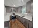 The kitchen features grey cabinets, stainless steel appliances, white countertops, and wood flooring at 487 Eastside Dr, Dacula, GA 30019