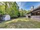 Spacious backyard is surrounded by mature trees with a large storage shed at 365 Othello Dr, Hampton, GA 30228