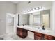 Bathroom showcasing a double vanity, large mirror, tile flooring, and doorway to another room at 365 Othello Dr, Hampton, GA 30228