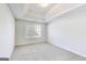 Bright bedroom with neutral carpeting, tray ceiling, and large window with blinds at 365 Othello Dr, Hampton, GA 30228