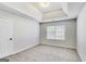Spacious bedroom with neutral carpeting, tray ceiling, and a window for natural light at 365 Othello Dr, Hampton, GA 30228