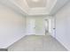 Large bedroom with neutral carpet, tray ceiling, two doors and view into an ensuite bathroom at 365 Othello Dr, Hampton, GA 30228