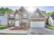 Charming two-story brick home with a manicured lawn and an attached two-car garage at 365 Othello Dr, Hampton, GA 30228