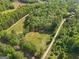 An aerial shot captures a blend of open land and dense trees, offering both privacy and accessibility to roadways at 2331 Hollonville Rd, Brooks, GA 30205